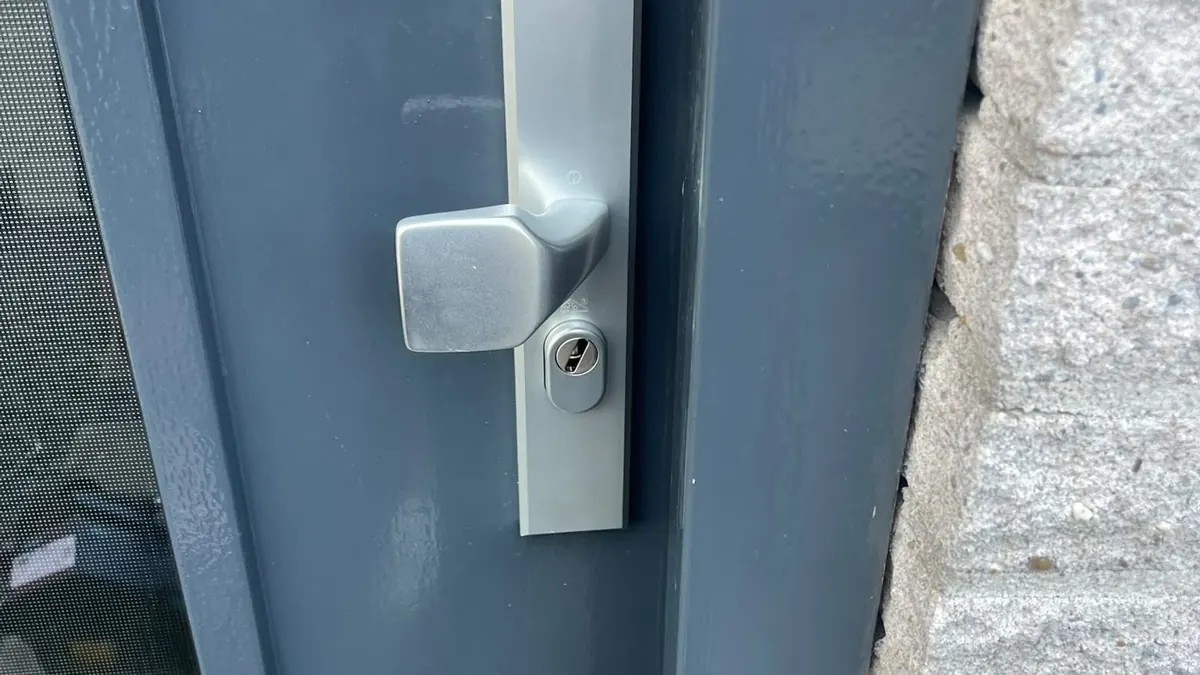 Aluminium veiligheidsbeslag met vaste knop en cilinder op een antracietgrijze buitendeur